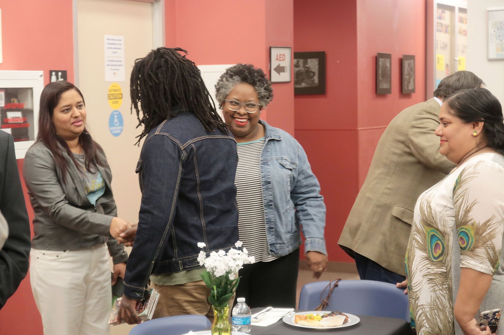 People greeting one another and talking at a community gathering