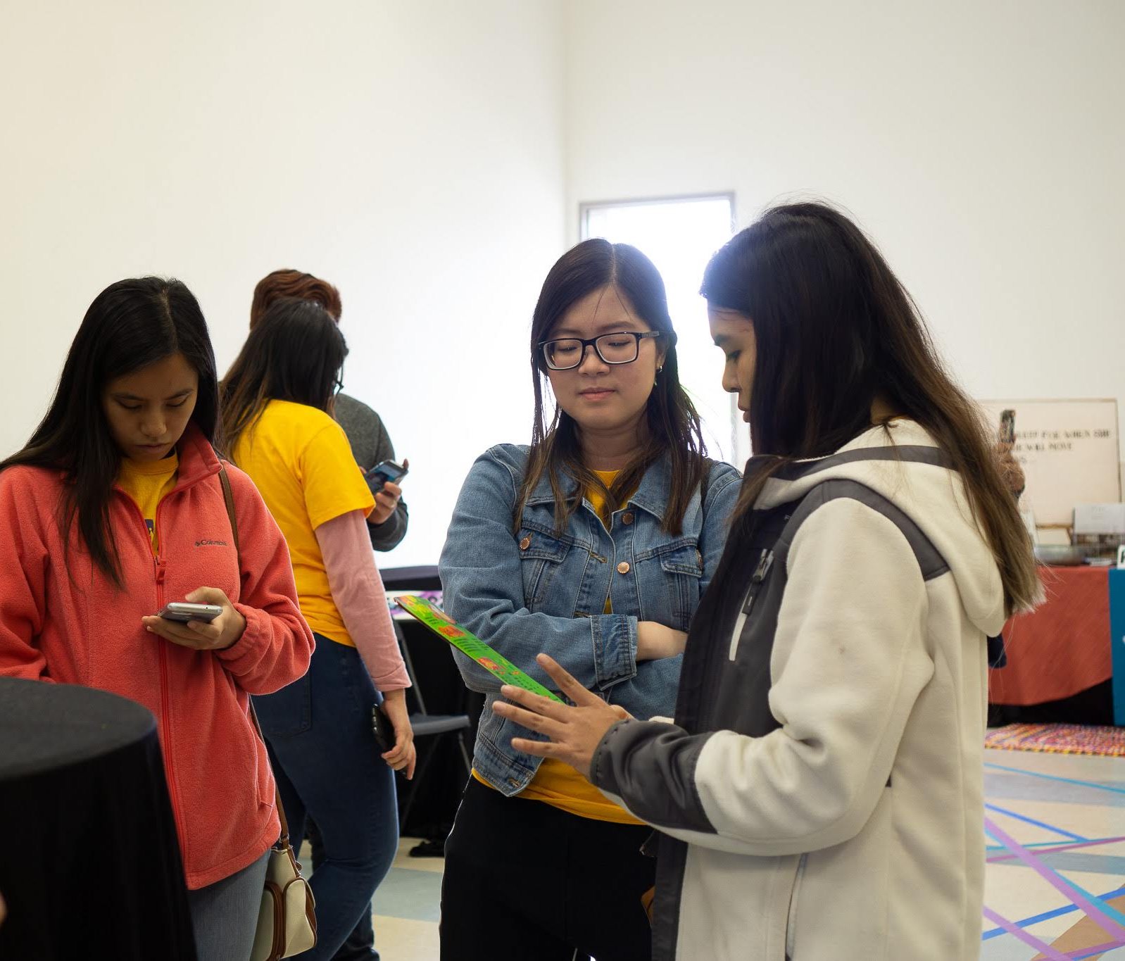 People reading printed information together at a community event